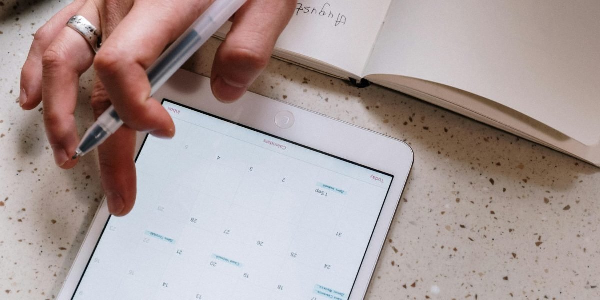 A person focused on organizing their movie watchlist, using a planner or a digital tool to manage viewing plans.