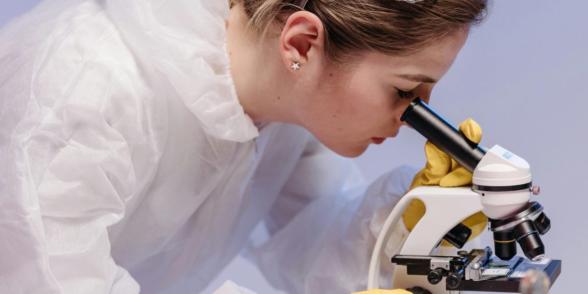 A person in a lab coat looks surprised and amazed by a scientific discovery.