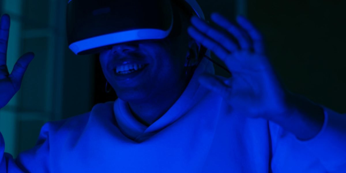 A person captivated by a futuristic film on a large screen, immersed in a world of advanced technology and profound stories.