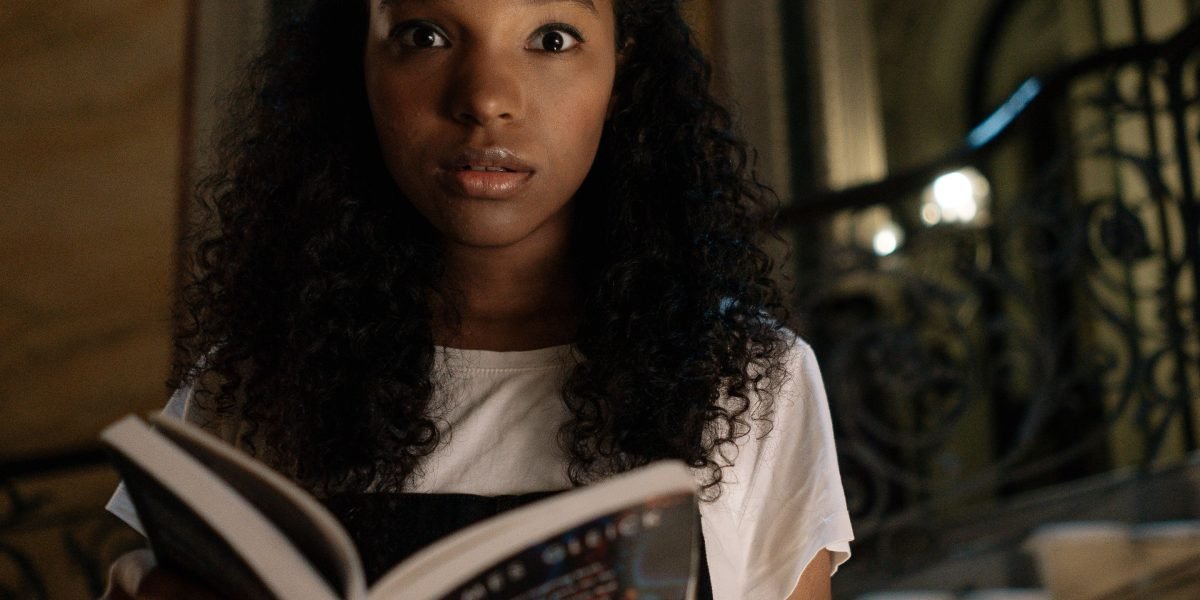 A person looking surprised and engaged while discovering an unexpected book recommendation.